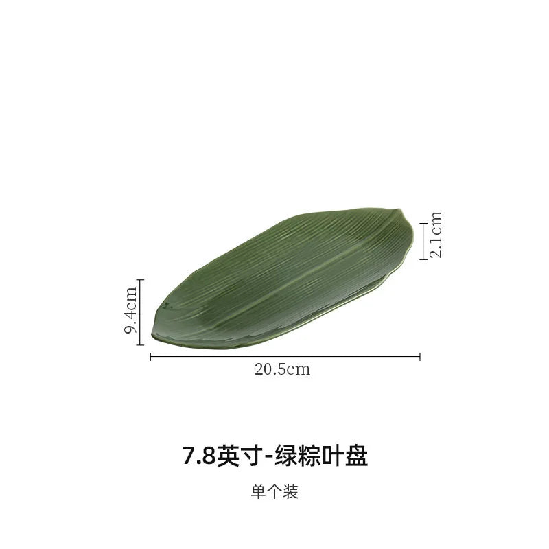 Elegante plato de sushi de cerámica con hojas de bambú verde para postres